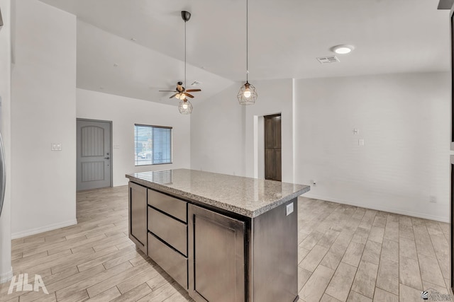 kitchen featuring wood finish floors, pendant lighting, a center island, lofted ceiling, and visible vents