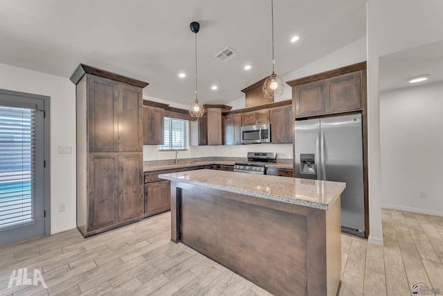 kitchen with lofted ceiling, appliances with stainless steel finishes, light stone counters, and wood tiled floor