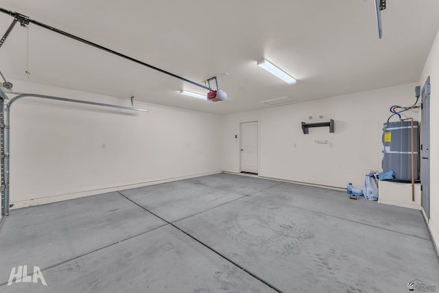 garage with strapped water heater and a garage door opener