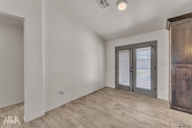 unfurnished room with light wood-type flooring, baseboards, and visible vents