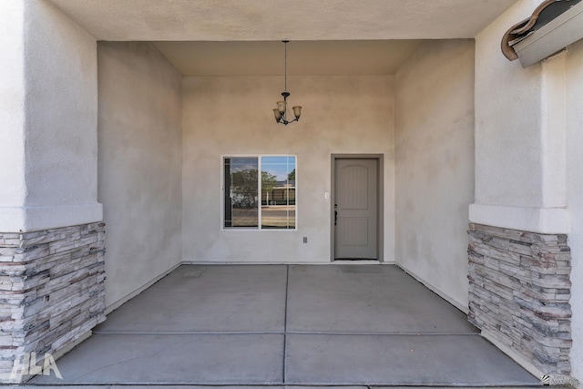 entrance to property featuring a patio area and stucco siding