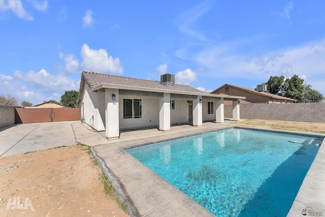 rear view of property with a fenced in pool, a fenced backyard, a patio, and central AC