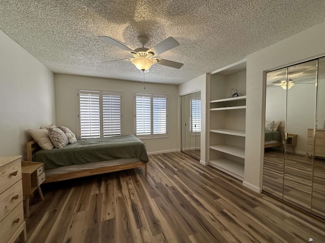 2240 S Elks Ln # 21, Yuma, AZ 85364 - bedroom with two closets, a textured ceiling, wood finished floors, ceiling fan, and baseboards