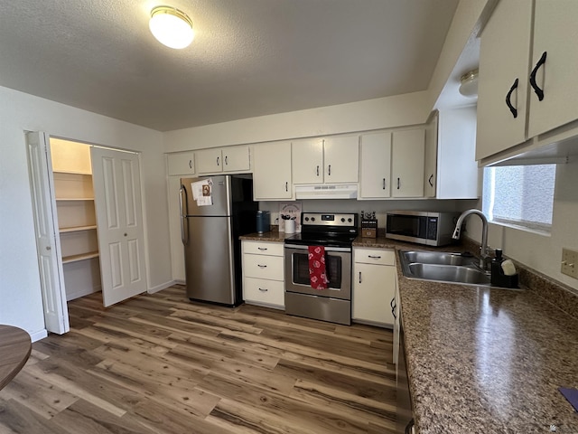 2240 S Elks Ln # 21, Yuma, AZ 85364 - kitchen with appliances with stainless steel finishes, under cabinet range hood, a sink, dark countertops, and white cabinets