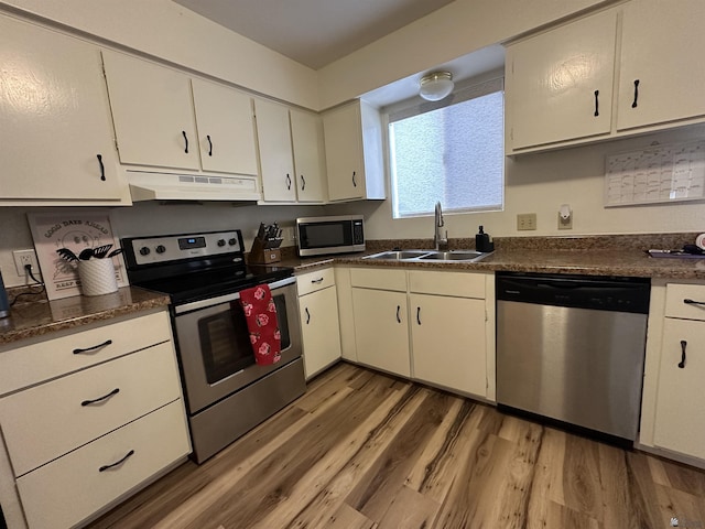 2240 S Elks Ln # 21, Yuma, AZ 85364 - kitchen with appliances with stainless steel finishes, under cabinet range hood, a sink, light wood-style flooring, and dark countertops