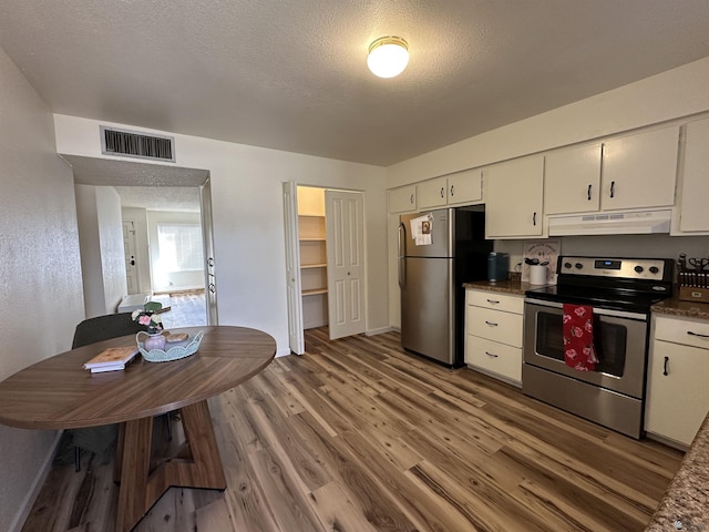 2240 S Elks Ln # 21, Yuma, AZ 85364 - kitchen featuring stainless steel appliances, under cabinet range hood, light wood-style floors, white cabinets, and dark countertops