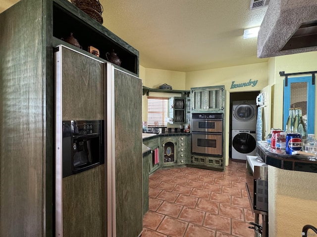 kitchen with stacked washer and dryer, open shelves, stainless steel double oven, and dark countertops