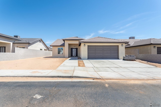 10849 E 45th Pl, Yuma, AZ 85367 - view of front facade with a tiled roof, stucco siding, an attached garage, and driveway