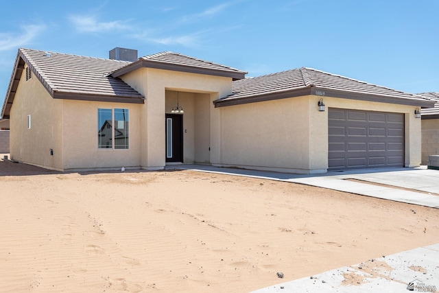 10849 E 45th Pl, Yuma, AZ 85367 - view of front of house with a garage, a tiled roof, stucco siding, and driveway