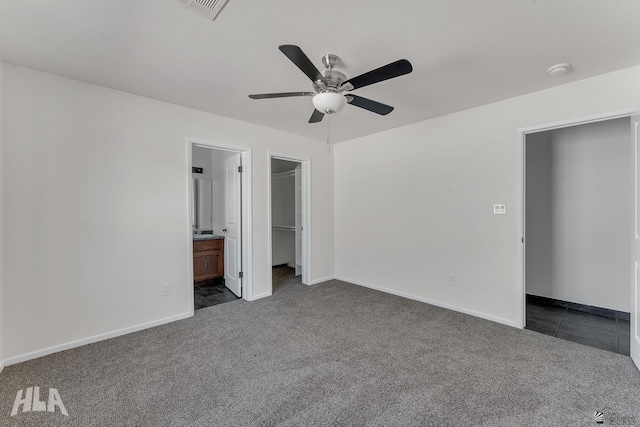 1124 N Villareal Ave, San Luis, AZ 85336 - unfurnished bedroom featuring dark carpet, baseboards, ensuite bathroom, and a spacious closet
