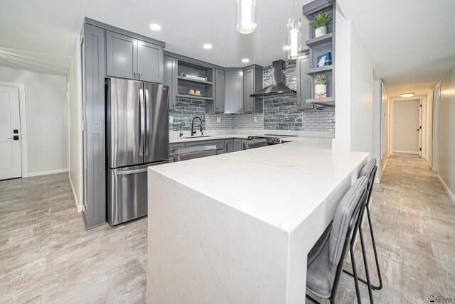 1790 S Meadowbrook Ave, Yuma, AZ 85364 - kitchen featuring open shelves, a sink, wall chimney exhaust hood, freestanding refrigerator, and a peninsula