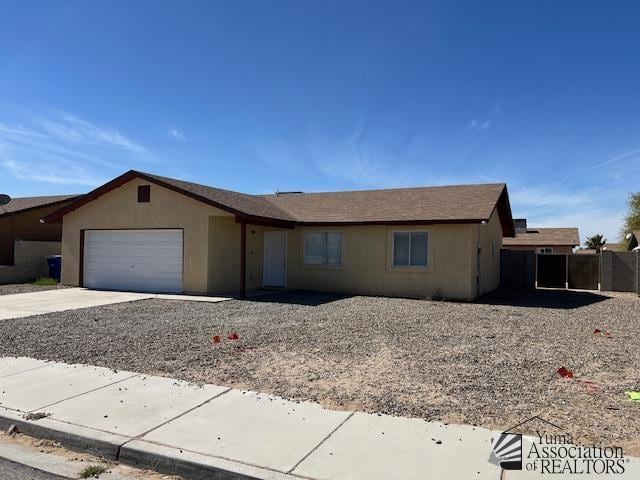 single story home with a garage, concrete driveway, fence, and stucco siding