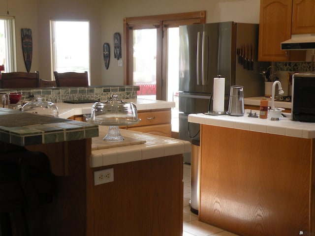 10224 S Fairway Ln, Yuma, AZ 85367 - kitchen with under cabinet range hood, tile countertops, and plenty of natural light