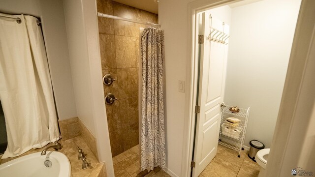 bathroom featuring a bath, tile patterned floors, toilet, and tiled shower