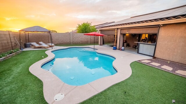 view of swimming pool featuring a fenced in pool, a fenced backyard, a patio area, and a yard