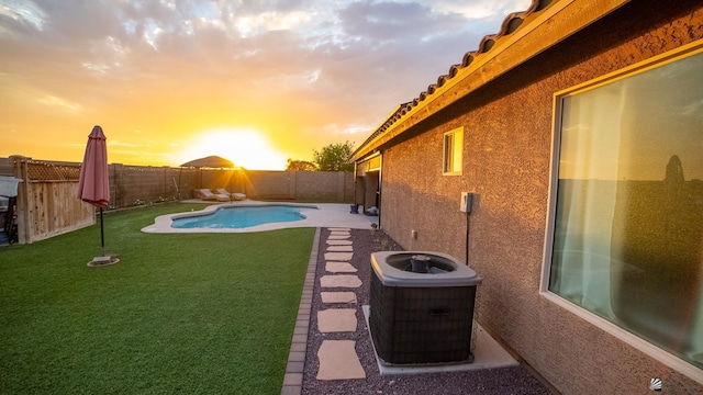 11681 E 36th St, Yuma, AZ 85367 - yard at dusk featuring a fenced backyard, a fenced in pool, and central AC unit