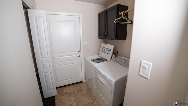 laundry room with washer and clothes dryer, cabinet space, and light tile patterned floors
