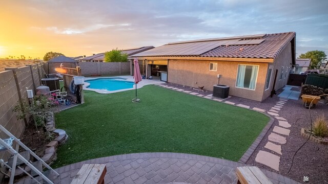 view of yard featuring a fenced in pool, a fenced backyard, a patio area, and cooling unit