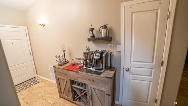 interior space featuring baseboards, visible vents, and light tile patterned floors
