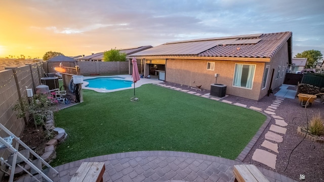 11681 E 36th St, Yuma, AZ 85367 - yard at dusk featuring central air condition unit, a fenced in pool, a fenced backyard, and a patio area
