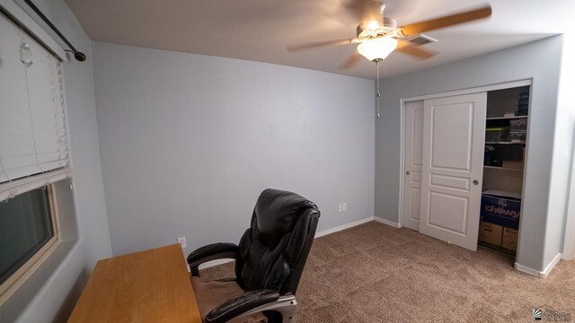 home office with baseboards, a ceiling fan, and light carpet