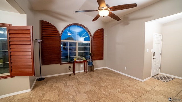 spare room with a ceiling fan and baseboards