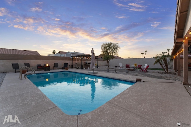 11683 E Via Salida, Yuma, AZ 85367 - pool at dusk featuring a fenced in pool, a fire pit, a patio area, and a fenced backyard