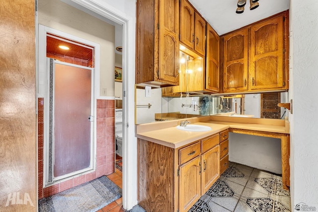 1802 S 11th Ave, Yuma, AZ 85364 - kitchen with light tile patterned floors, a sink, light countertops, tile walls, and brown cabinets