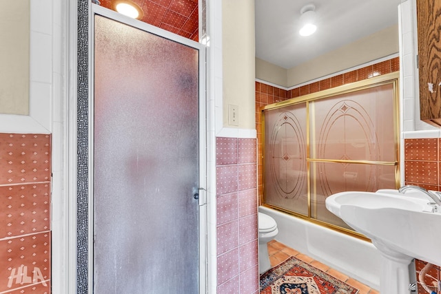1802 S 11th Ave, Yuma, AZ 85364 - bathroom with tile walls, toilet, enclosed tub / shower combo, tile patterned flooring, and a sink
