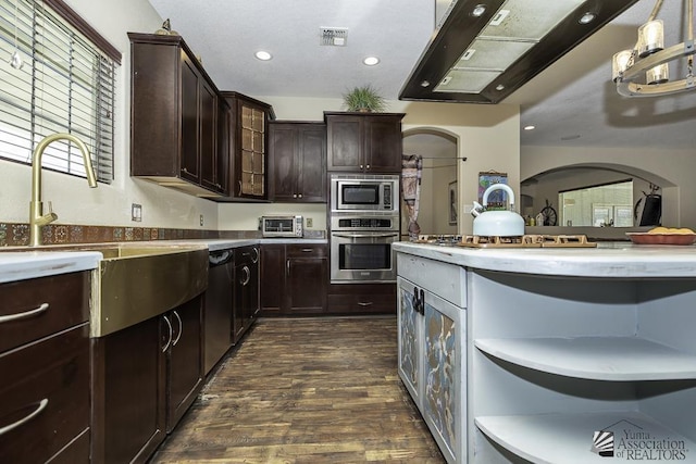 kitchen featuring dark wood-style flooring, appliances with stainless steel finishes, range hood, open shelves, and a sink