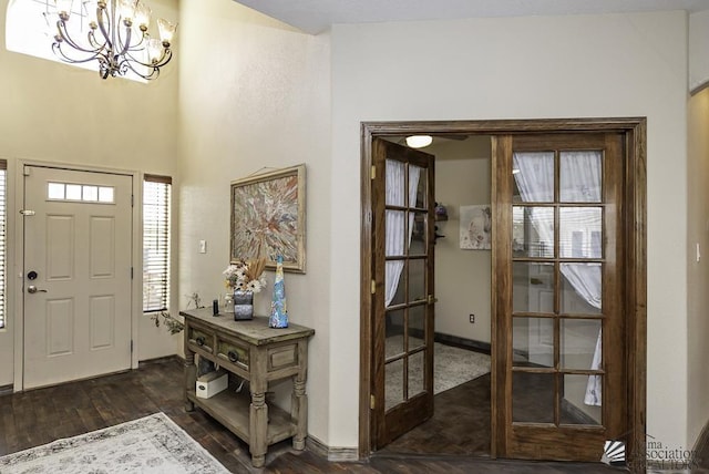 entryway featuring an inviting chandelier, baseboards, and dark wood-style floors