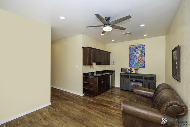 kitchen with dark wood-style flooring, dark brown cabinets, ceiling fan, dark countertops, and a sink
