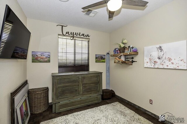 bedroom with visible vents, baseboards, dark wood-type flooring, and ceiling fan