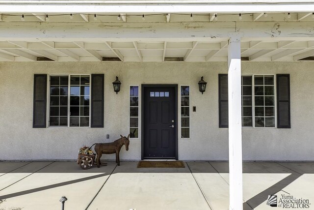 property entrance featuring stucco siding and a porch