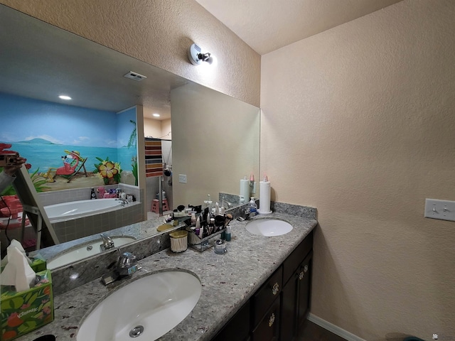 bathroom featuring visible vents, a sink, a textured wall, and double vanity