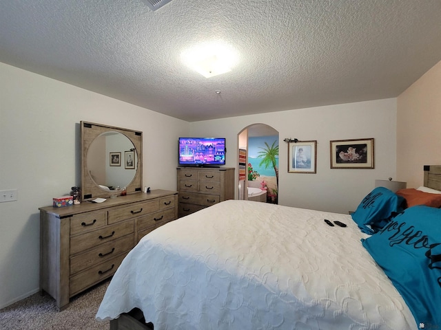 bedroom with carpet flooring, arched walkways, and a textured ceiling