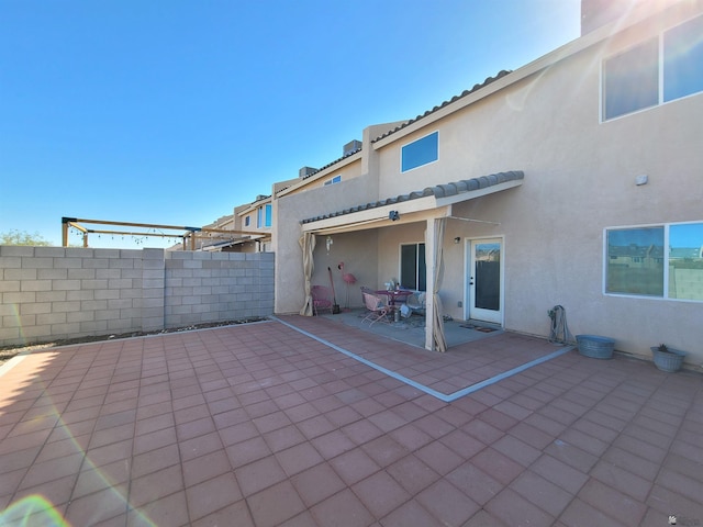 back of property featuring a patio, fence, and stucco siding