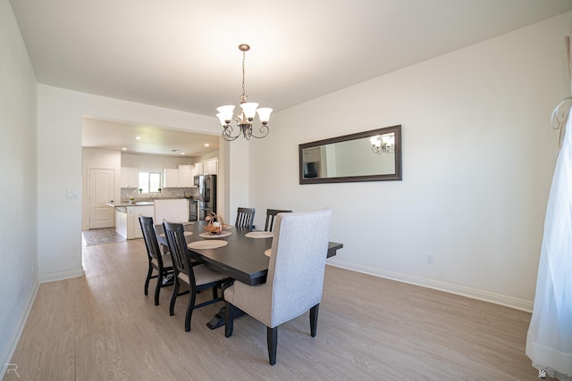 dining area featuring an inviting chandelier, baseboards, recessed lighting, and light wood-style flooring
