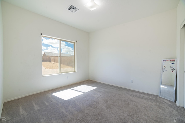spare room featuring visible vents, carpet flooring, and baseboards