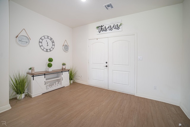 entryway featuring baseboards, light wood-type flooring, and visible vents