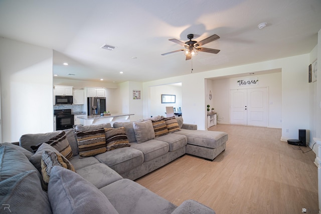 living area with ceiling fan, visible vents, baseboards, recessed lighting, and light wood-style flooring