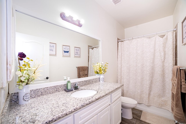 full bathroom featuring visible vents, wood finished floors, shower / tub combo, vanity, and toilet
