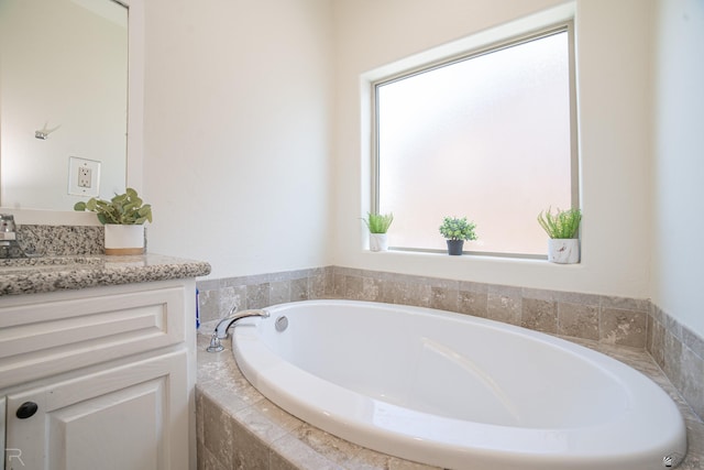 bathroom featuring vanity, plenty of natural light, and a garden tub