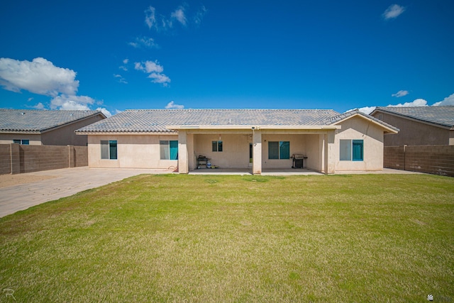back of house featuring a patio, a fenced backyard, stucco siding, and a yard
