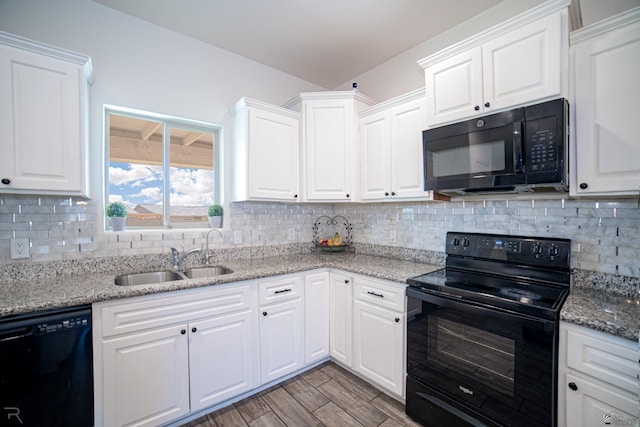 kitchen with decorative backsplash, a sink, white cabinets, black appliances, and light wood finished floors