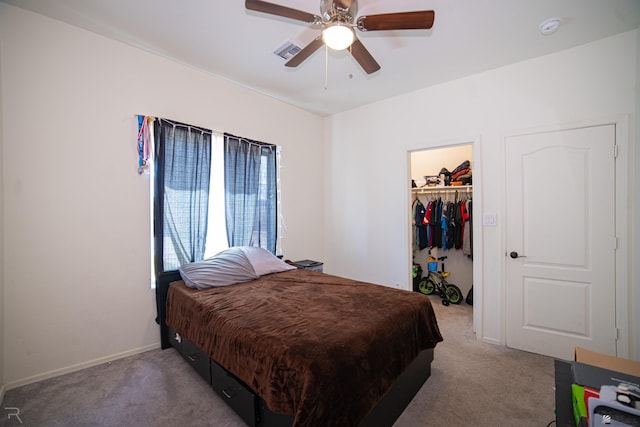carpeted bedroom with a walk in closet, ceiling fan, visible vents, baseboards, and a closet