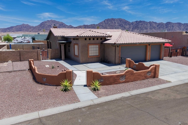 12839 S Drucilla Ln, Yuma, AZ 85367 - view of front facade with a fenced front yard, a gate, a mountain view, a tile roof, and concrete driveway