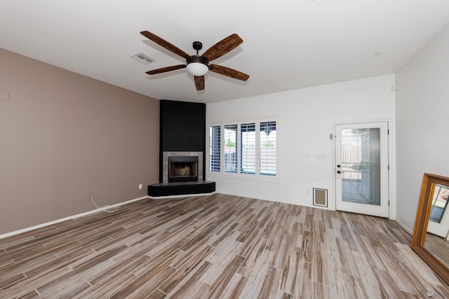 12839 S Drucilla Ln, Yuma, AZ 85367 - unfurnished living room with light wood-style flooring, a ceiling fan, a fireplace, and baseboards