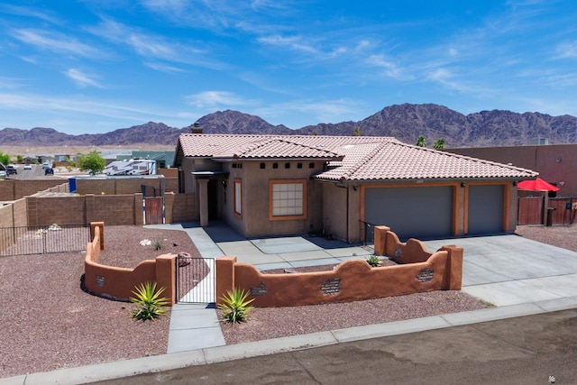 12839 S Drucilla Ln, Yuma, AZ 85367 - view of front of property with a fenced front yard, a gate, a mountain view, a tiled roof, and an attached garage