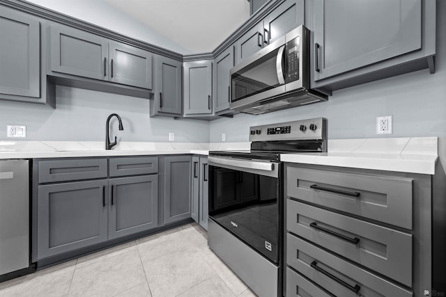 10858 E 45th Ln, Yuma, AZ 85367 - kitchen featuring stainless steel appliances, gray cabinetry, a sink, light stone counters, and light tile patterned floors